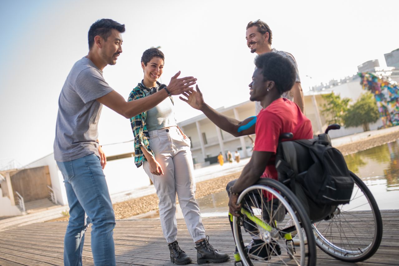 Friends greet each other outdoors in Portugal, promoting diversity and inclusion.